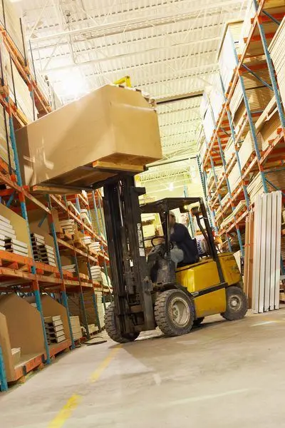 Forklift operating in a sub-zero freezer warehouse aisle